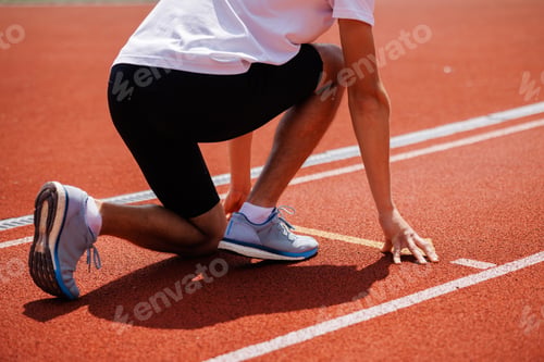 Preview: Athlete in starting position on running track
