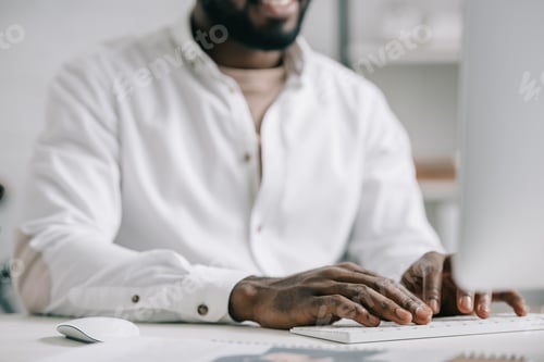 Preview: cropped image of african american businessman working at computer in office