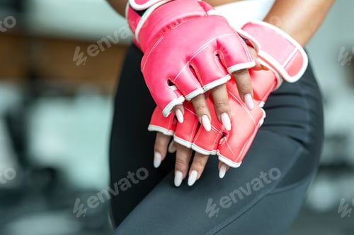 Preview: Be the change you wished to see. Sportswoman wearing kickboxing gloves for training in gym.