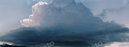 Preview: Thunderstorm cumulus clouds in sunbeams in blue sky