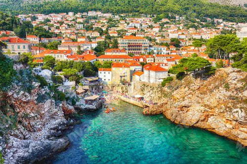 Preview: view at famous travel destination city of Dubrovnik - Suluci beach and old city on a sunny day.