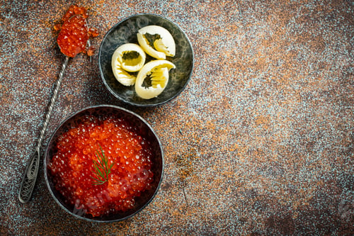 Preview: Delicious red caviar in black bowl.