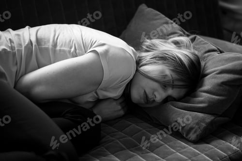 Preview: Young woman lying down on sofa and having a nap