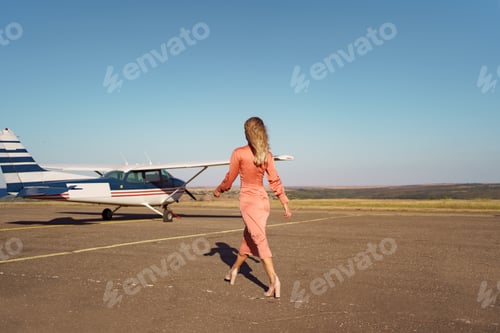Preview: Woman in Elegant Dress Walks Toward Private Plane