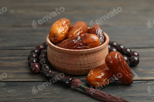 Preview: Wooden bowl with dates and prayer beads on wooden background