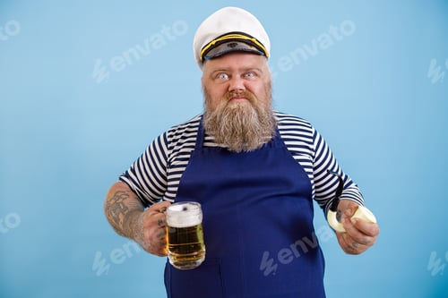 Preview: Funny obese sailor with apron holds pipe and delicious beer on light blue background