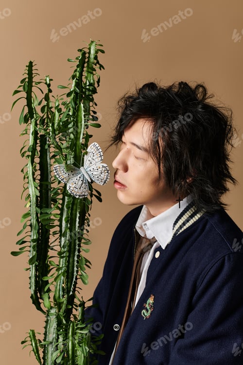 Preview: Spring fashion: a stylish Asian man with a lovely plant and butterfly