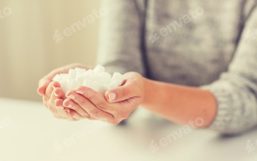 Preview: close up of white lump sugar in woman hands