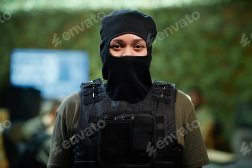 Preview: Young serious female military officer in black balaclava and body armor