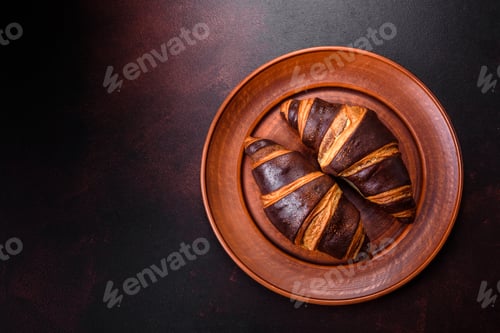 Preview: Beautiful tasty fresh crispy croissant on a dark concrete background