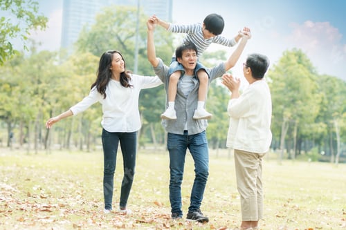Preview: Happy young family spending time together outside in green nature and park
