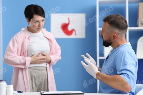 Preview: Gastroenterologist consulting patient with stomach pain in clinic, selective focus