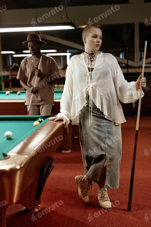 Preview: Bald young woman standing by pool table
