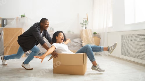 Preview: African american husband rolling his wife in cardboard box