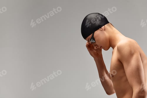 Preview: Young athletic man ready to jump into swimming pool against gray background. The concept of swimming