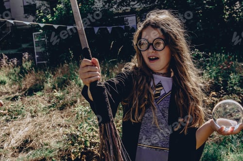 Preview: teenage girl celebrates the Halloween party, the witch costume from Harry Potter. Magic ball