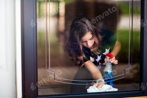 Preview: Girl bending down to clean glass door