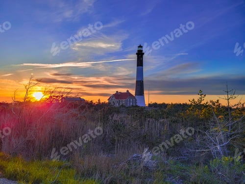Preview: Lighthouse in a forest during a colorful sunset