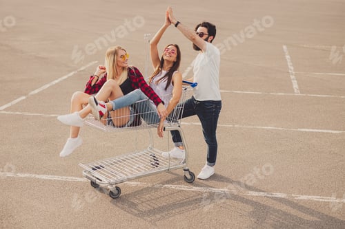 Preview: Young hipsters with shopping trolley doing high five