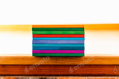 Preview: Several books stacked by their backs of different colors like rainbow, empty to fill with text.