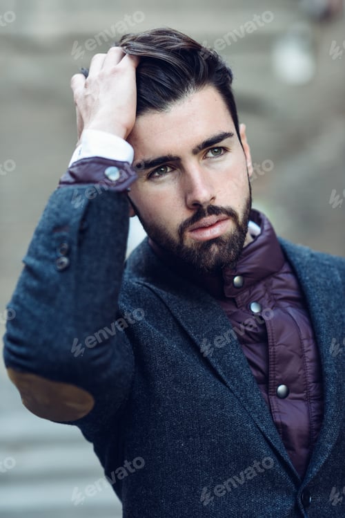 Preview: Young bearded man in urban background wearing british elegant suit in the street