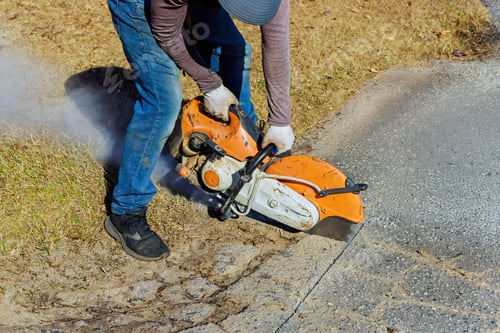 Preview: This construction worker uses a diamond blade saw machine to cut damaged asphalt pavement
