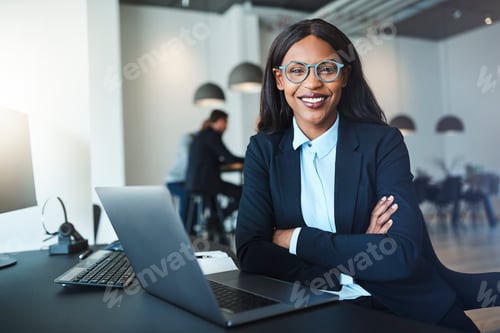 Preview: Confident young African American businesswoman sitting at her office desk
