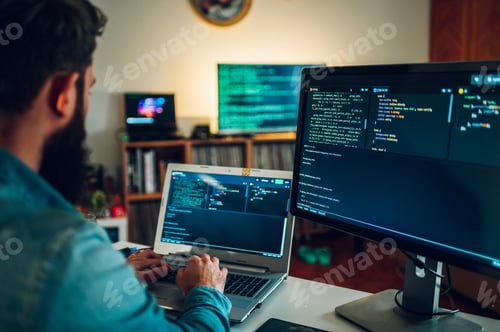 Preview: A database scientist is entering data on his laptop while sitting in a home surrounded by screens.
