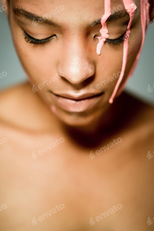 Preview: Ethnic woman with paint on face in studio