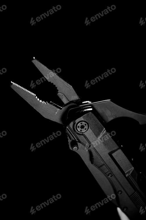 Preview: Vertical grayscale shot of pliers tool against a dark background