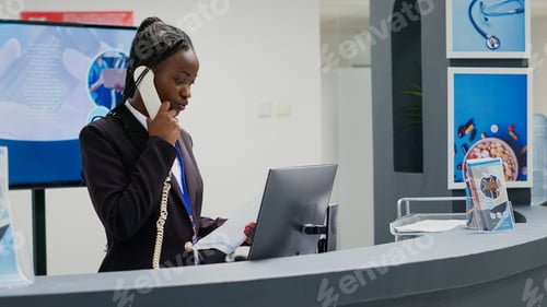 Preview: Young receptionist working at clinic reception counter