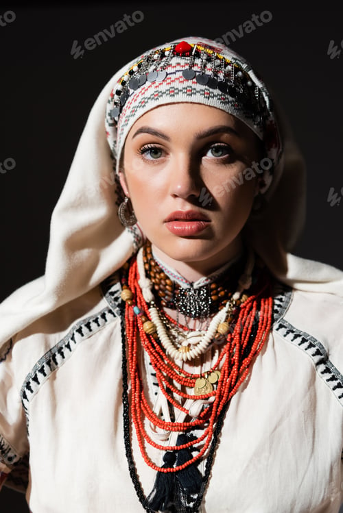 Preview: portrait of ukrainian woman in traditional shirt with red ornament and headwear looking at camera