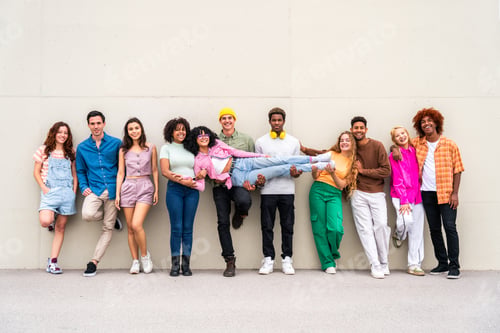 Preview: Happy playful multiethnic group of young friends bonding outdoors