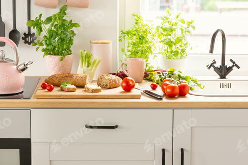 Preview: Close-up of bread, tomatoes and plants on a countertop in a kitc
