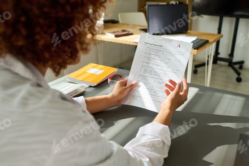Preview: African American female teenage student looking through tasks of test
