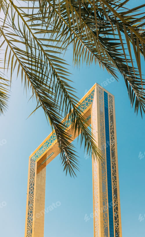 Preview: Vertical High quality photo. View Of Dubai Frame On Sunny Blue Sky Under Palm Branches. Dubai Frame