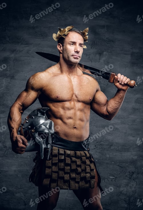 Preview: Middle age, muscular male holds silver gladiator helmet and an i