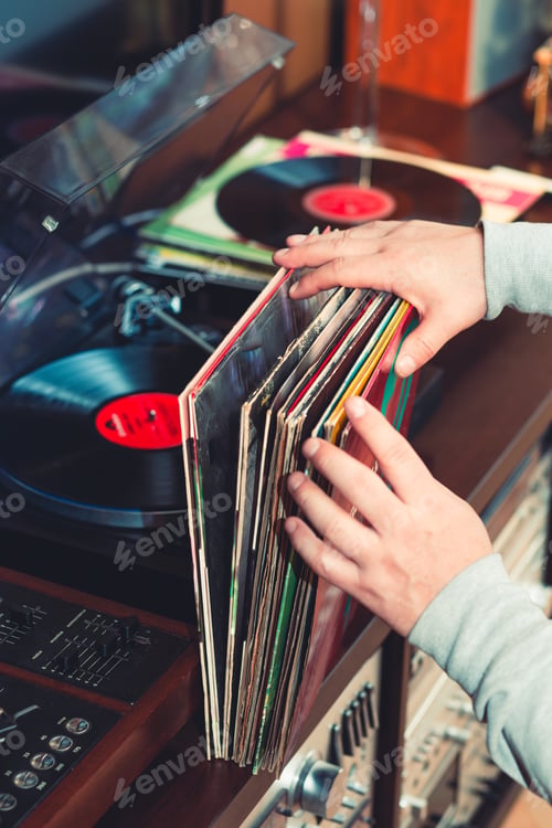 Preview: Man holding bunch of vinyl records. Set of audio equipment, record players, amplifiers, radio. Vinyl