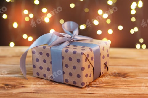 Preview: Festive Wrapped Gift with Ribbon on Wooden Surface