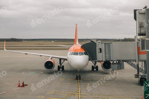 Preview: A large orange and white airplane is parked on the tarmac