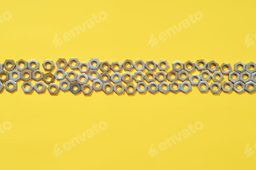 Preview: Horizontal metal nuts line on yellow