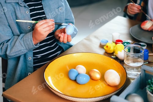 Preview: Kids painting wooden Easter eggs for home decoration.
