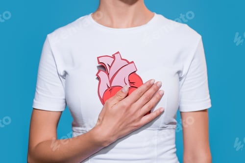 Preview: cropped shot of woman in white tshirt with paper made heart on blue backdrop