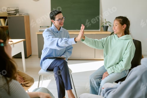 Preview: Caucasian Female Therapist Encouraging Asian Teenage Girl during Group Session