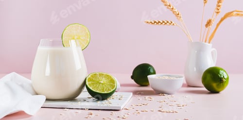 Preview: Homemade oatzempic drink of oat milk and lime in a glass on the table web banner