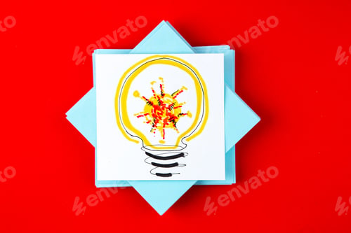 Preview: top view blue paper stickers with lightbulb drawing on red background vaccine covid- color pill