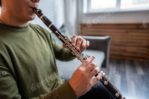 Preview: Clarinet player. Clarinetist hands playing flute woodwind music instrument at home. Guy plays oboe