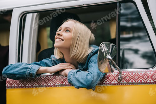 Preview: happy beautiful blonde girl sitting in retro styled minivan