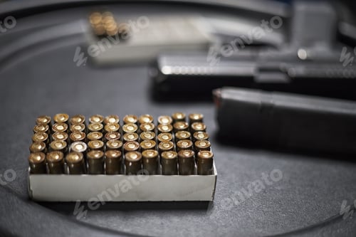 Preview: Closeup of Handgun Magazine and Bullets Arranged on Table in Shooting Range