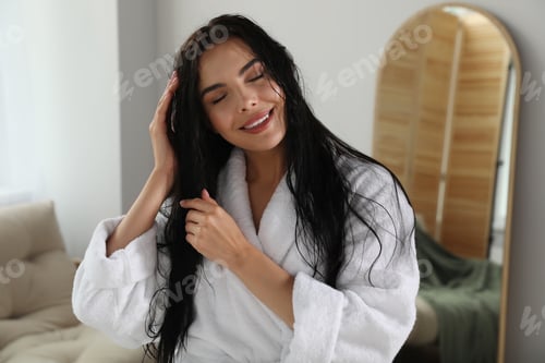 Preview: Beautiful young woman wearing white bathrobe indoors